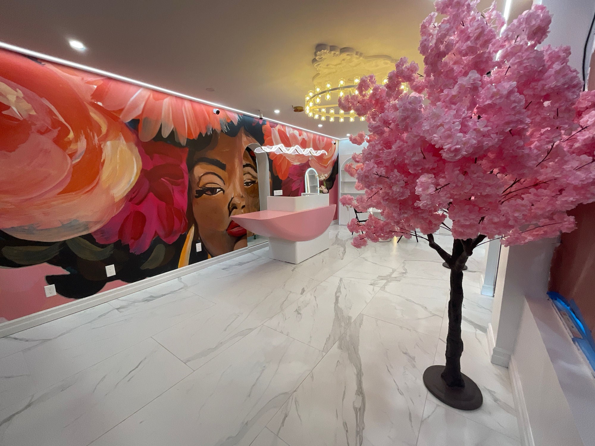 Inside the Legacy Flowers boutique in St. Albans — marble floors, a hand-painted floral mural, and a cherry-blossom tree